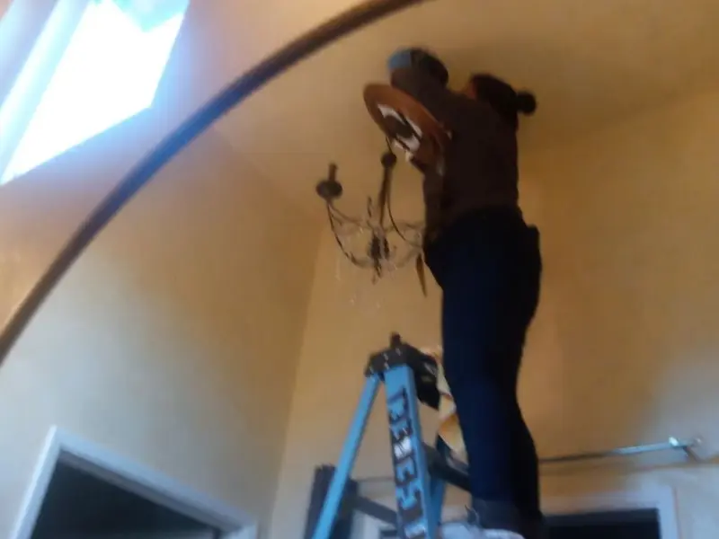 Electrician installing a chandelier in a Boulder Hill residence